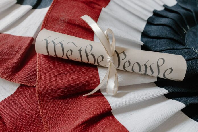 Fragment konstytucji USA z napisem We the People na tle flagi USA Fragment konstytucji USA z napisem We the People na tle flagi USA