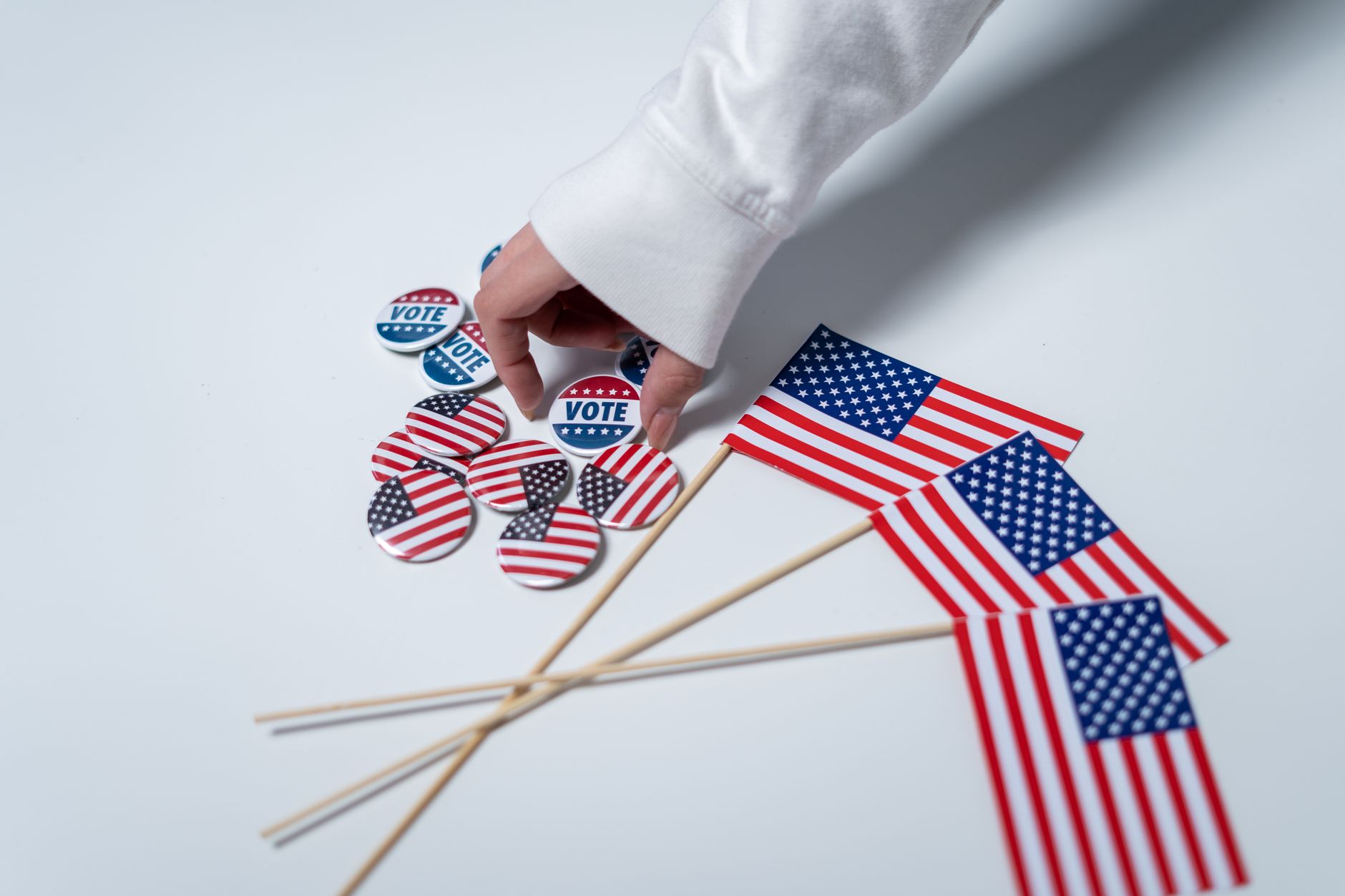 Dłoń naciskająca przyciski do głosowania, obok flagi USA