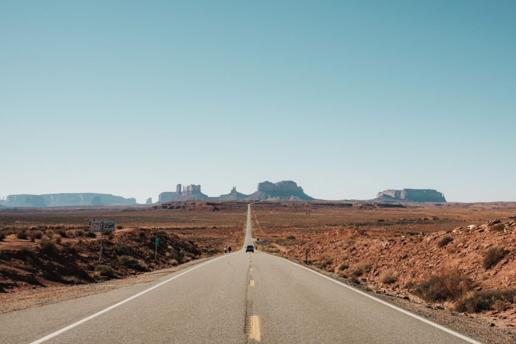 Malownicza droga prowadząca przez Monument Valley pod bezchmurnym niebem